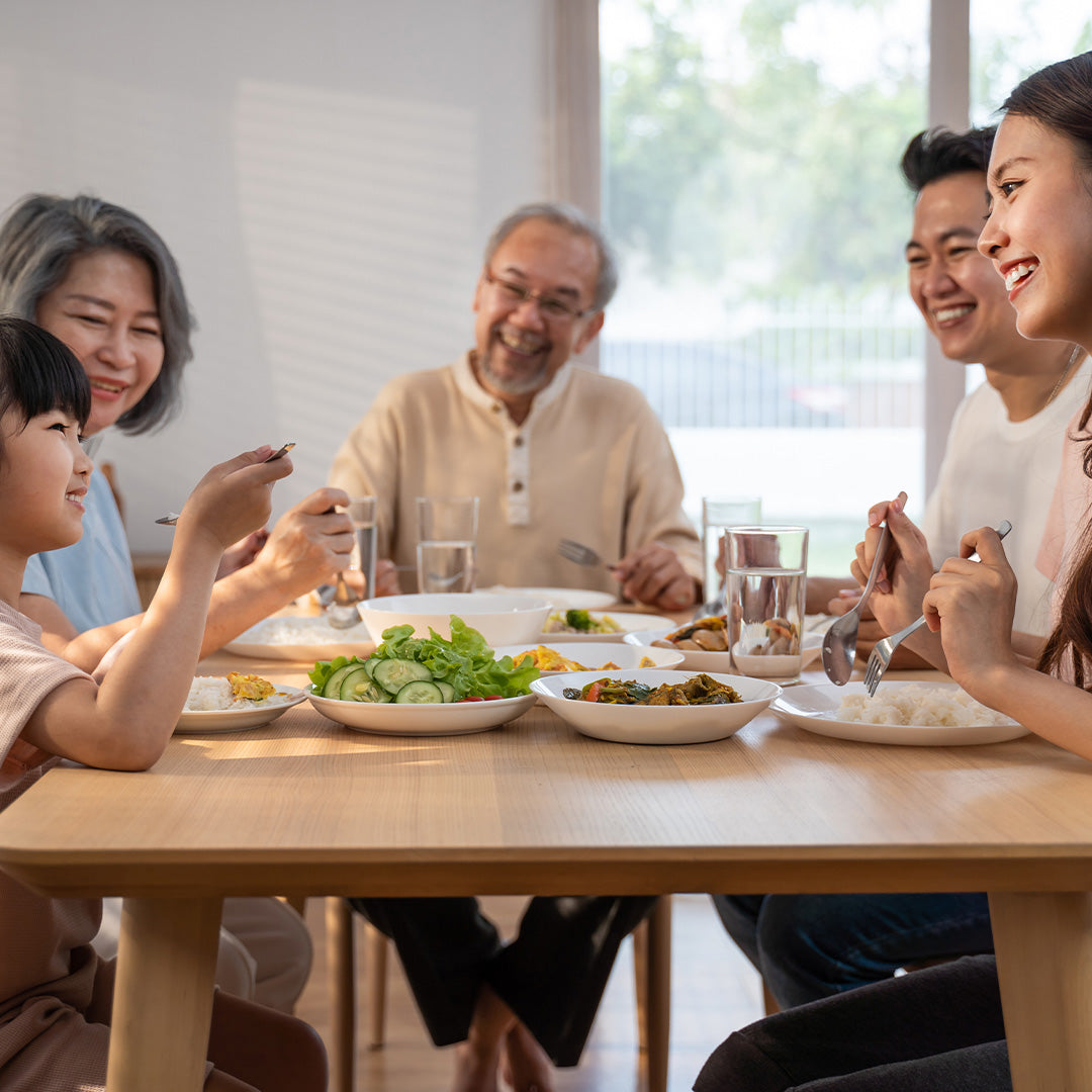 Family enjoying a meal at a wooden dining table.
