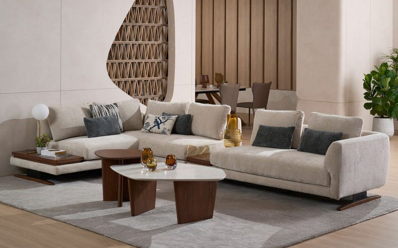 modern living room with a large beige sectional sofa decorated with throw pillows, paired with two wooden coffee tables on a grey rug